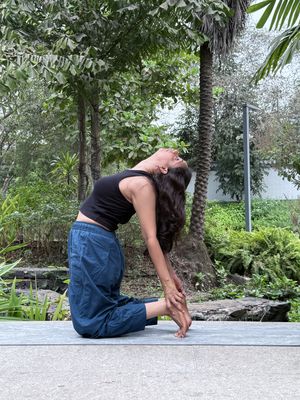 Prajakta Gogate practicing Camel posture (Ustrasana) in a garden