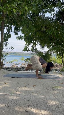 Prajakta Gogate performing Crow posture (Bakasana) on the beach